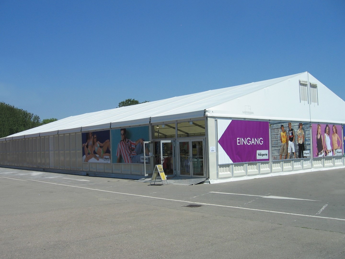Employees smiling in front of tent