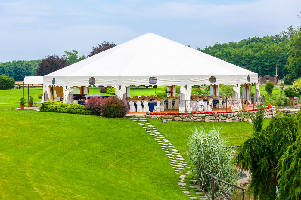 a large outdoor wedding tent with tables and chairs set up underneath it