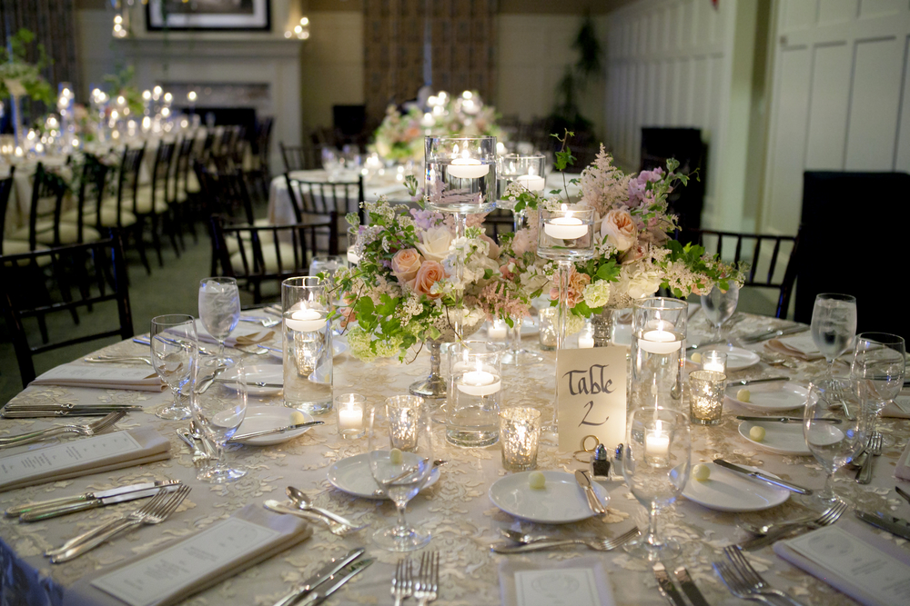 a table at a wedding decorated with flowers and laid with silverware and linens