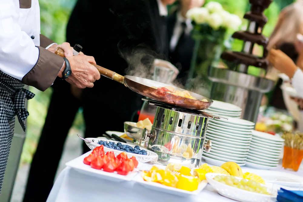 catering staff serving food at an outdoor wedding