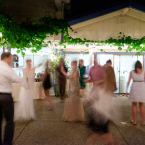 wedding guests and the bride and groom dancing outside of a wedding tent