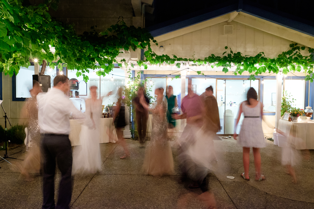 wedding guests and the bride and groom dancing outside of a wedding tent