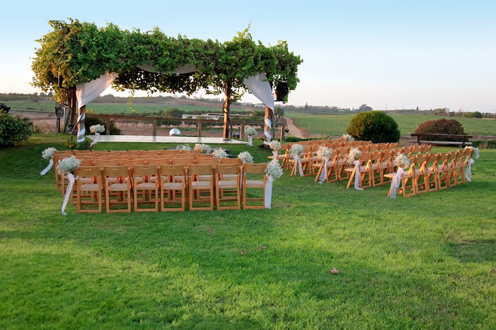 an outdoor wedding with rows of chairs waiting for guests