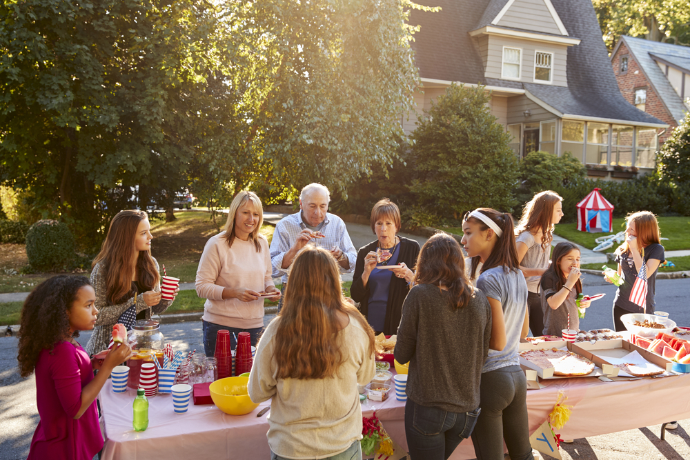 neighbors at a block party eating at a table