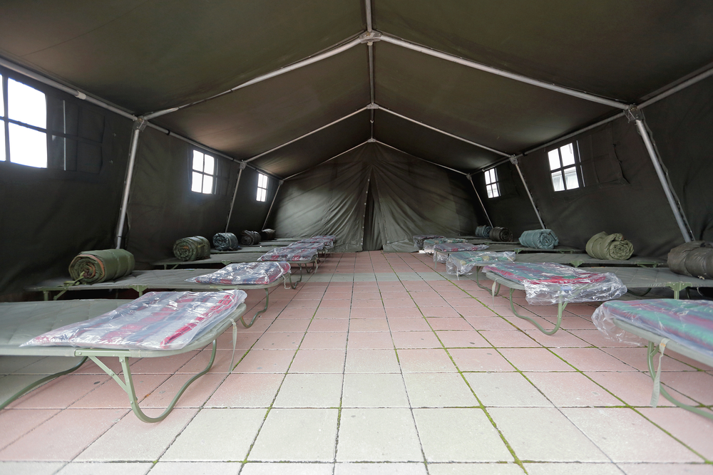 a large tent with cots for sleeping set up as a shelter