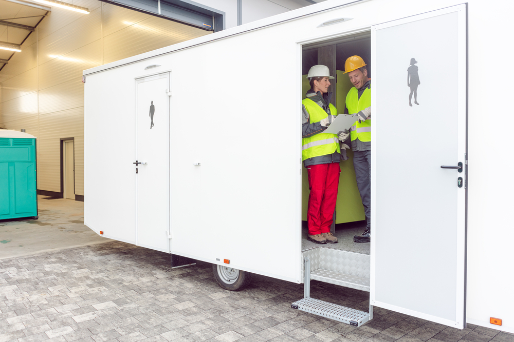 workers in a portable toilet trailer