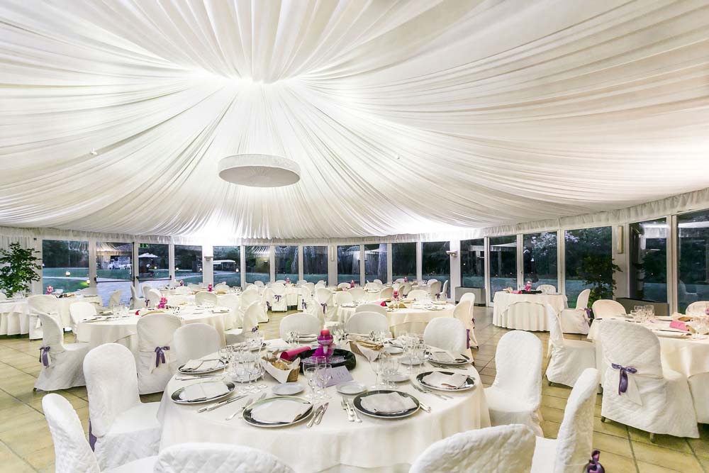 an event tent set up for a wedding reception with glass sidewalls