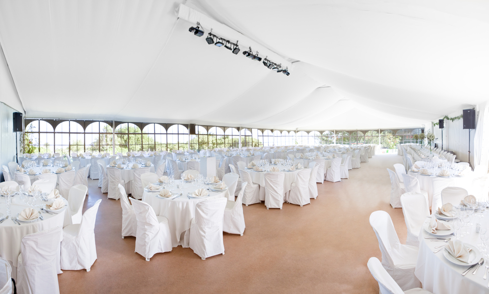 a wedding event tent with lots of tables inside waiting for guests
