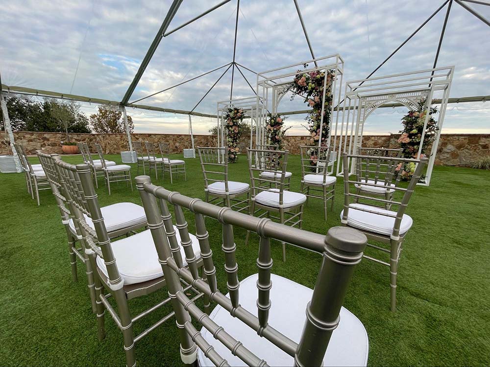 stacked rental chairs from a wedding under a rental tent from iRentEverything at Bella Collina Clubhouse