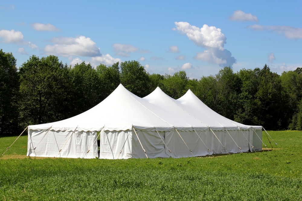 an event tent with sidewalls that has been secured to the ground with ropes and stakes