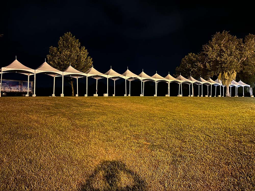 A long line of several outdoor tents stationed for a music festival