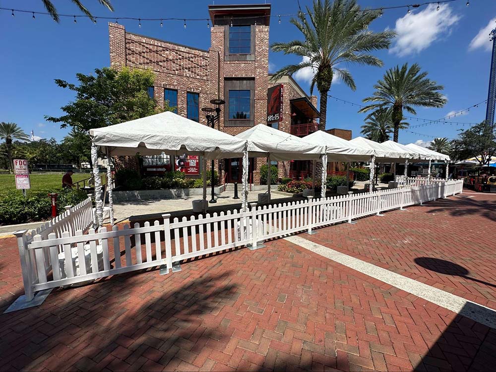 A row of outdoor tents stationed outside of Ole Red with white fences surrounding them