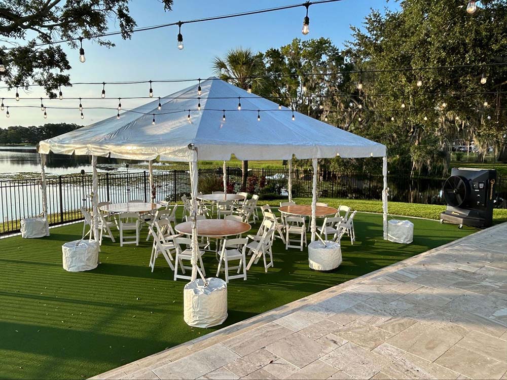 A small outdoor tent with tables and chairs stationed underneath