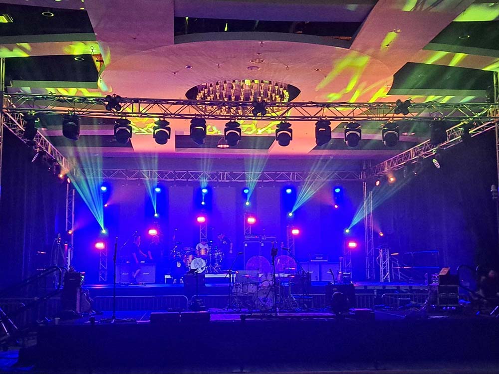 An indoor stage with blue, purple, and green LED lights